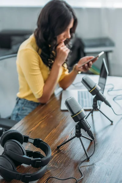 Selective Focus Radio Host Using Smartphone While Sitting Workplace Microphones — Stock Photo, Image