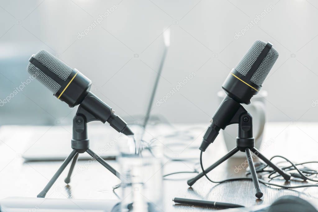 selective focus of two microphones on wooden table in broadcasting studio