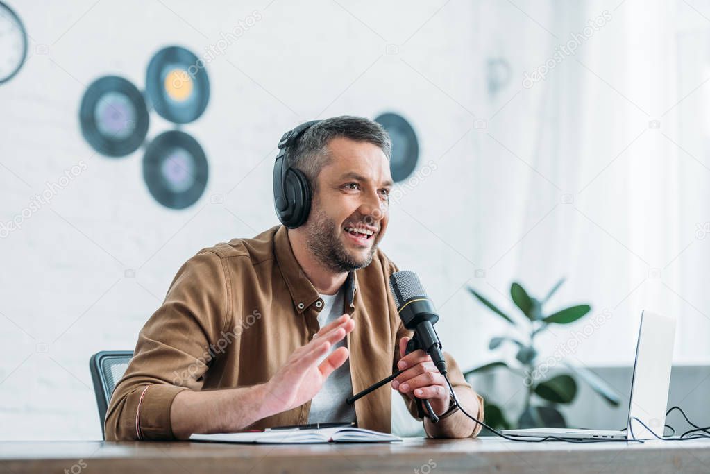 cheerful radio host gesturing while recording podcast in broadcasting studio