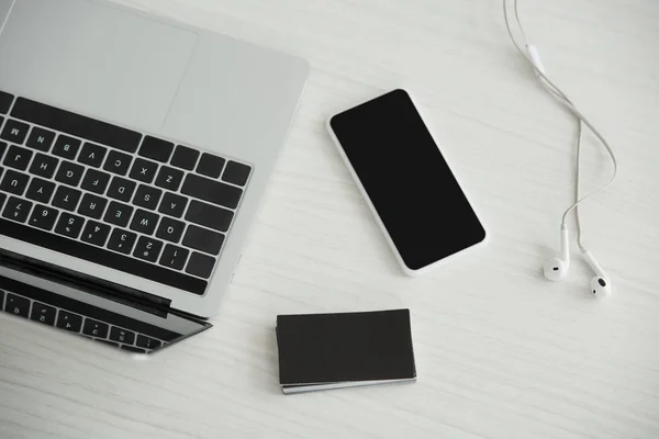 노트북의 상단보기 이어폰과 사무실 테이블에 명함의 스마트 — 스톡 사진