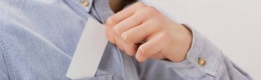 partial view of businessman getting white blank business card out of pocket, panoramic shot clipart