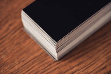 stack of black empty business cards on brown wooden tabletop clipart