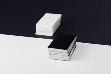 stacks of empty business cards on divided black and white background clipart