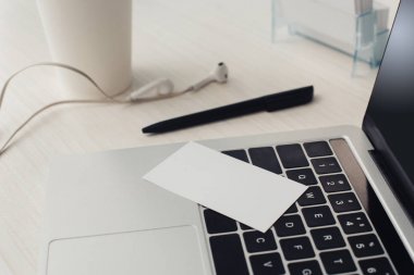 dizüstü bilgisayar klavyesi, kalem ve ofis masasında kulaklık boş kartvizit