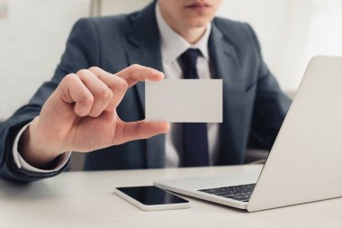 işyerinde otururken kamera boş kartvizit gösteren işadamı kısmi görünümü