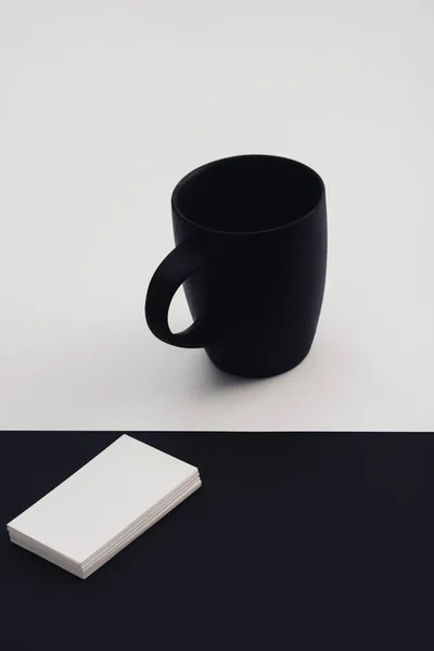 黒と白の背景に白い名刺と黒いコーヒーカップ — ストック写真