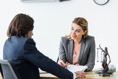 ofiste mutlu avukat yanında otururken sözleşme bakıyor işadamı