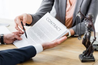 cropped view of businesspeople with contract in hands clipart