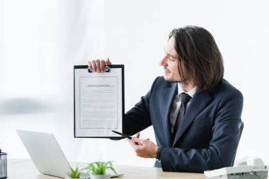 sigorta talep formunda kalemle işaret eden işadamı