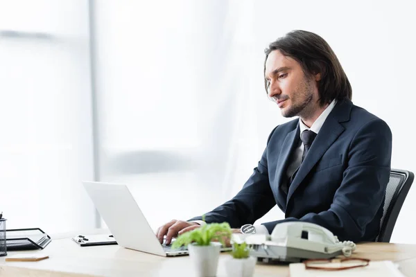 Όμορφος Επιχειρηματίας Κάθεται Στο Γραφείο Και Χρησιμοποιώντας Laptop — Φωτογραφία Αρχείου