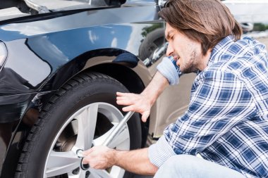 araç kullanarak yorgun adam ve otomatik kırık tekerlek değiştirme, araba sigortası kavramı