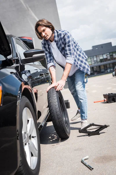 Man Rullande Nya Hjulet Och Fastställande Trasiga Auto Bilförsäkring Koncept — Stockfoto