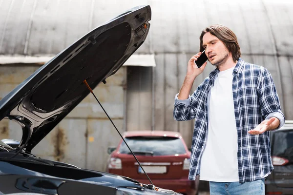開いているトランクで壊れた自動車の近くに立っている間にスマートフォンで話す男 自動車保険の概念 — ストック写真