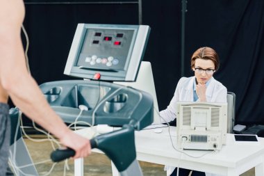 spor salonunda sporcu ile dayanıklılık testi yürüten masada doktor