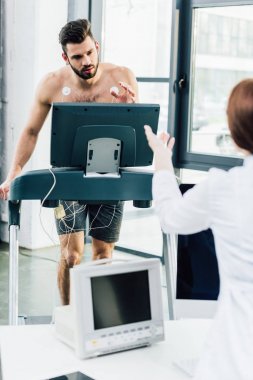 spor salonunda sporcu ile dayanıklılık testi yaparken doktor gesturing