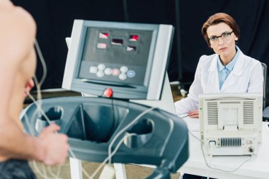 spor salonunda sporcu ile dayanıklılık testi yürüten güzel doktor