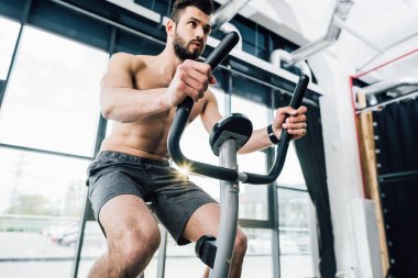 spor salonunda eliptik makine üzerinde yakışıklı sakallı sporcu eğitimi