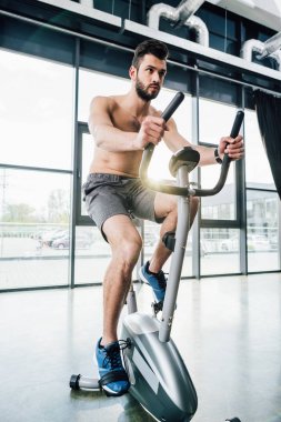 spor merkezinde eliptik makine üzerinde yakışıklı sporcu eğitimi
