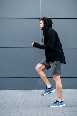 koşmaya hazır başlangıç pozisyonunda yakışıklı sporcunun yan görünümü