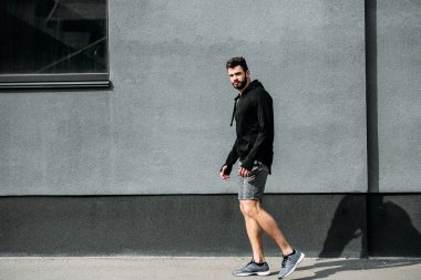 kopya alanı ile gri duvar yakınında poz spor giyim yakışıklı adam
