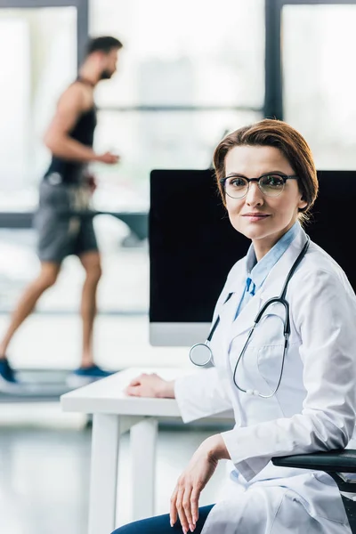 Beautiful Doctor Sitting Computer Desk Gym Looking Camera — Stock Photo, Image