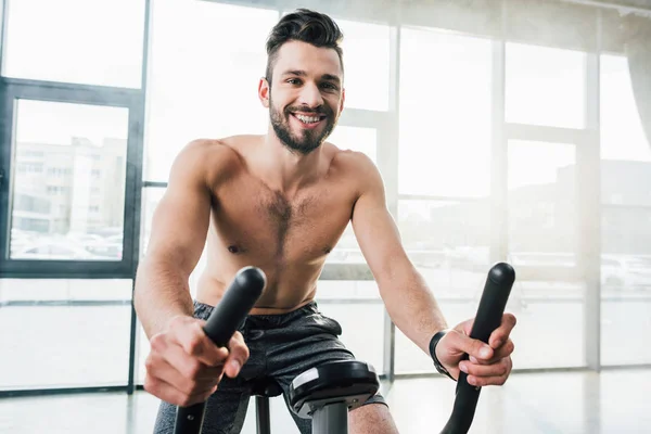 Lächelnder Gutaussehender Sportler Der Fitnessstudio Auf Einem Crossgerät Trainiert — Stockfoto