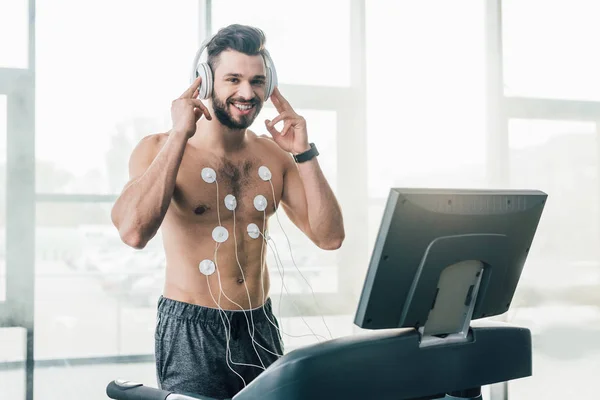 Sorridente Desportista Muscular Fones Ouvido Correndo Esteira Rolante Durante Teste — Fotografia de Stock