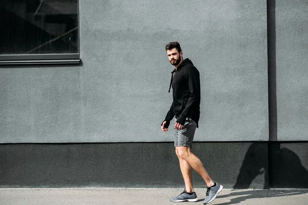 Bell Uomo Abbigliamento Sportivo Posa Vicino Muro Grigio Con Spazio — Foto Stock