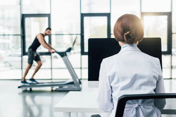Back View Doctor Using Computer While Sportsman Running Treadmill Endurance — Stock Photo, Image