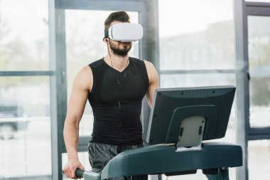 spor salonunda koşu bandı üzerinde çalışan sanal gerçeklik kulaklık sporcu