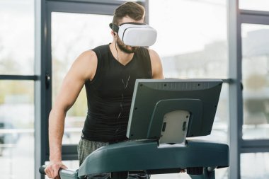 spor merkezinde koşu bandı üzerinde çalışan sanal gerçeklik kulaklık sporcu