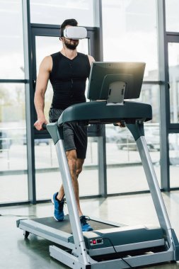 spor merkezinde koşu bandı üzerinde çalışan sanal gerçeklik kulaklık sporcu
