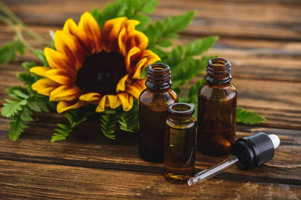 Sunflower Fern Leaves Bottles Essential Oils Dropper Wooden Surface — Stock Photo, Image