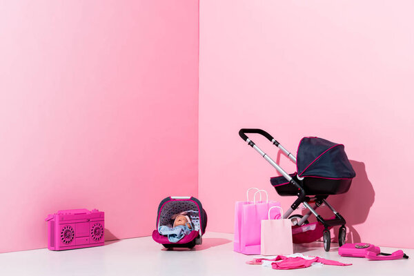 детская коляска, кукла в детской коляске, сумки и бумбокс на розовый
