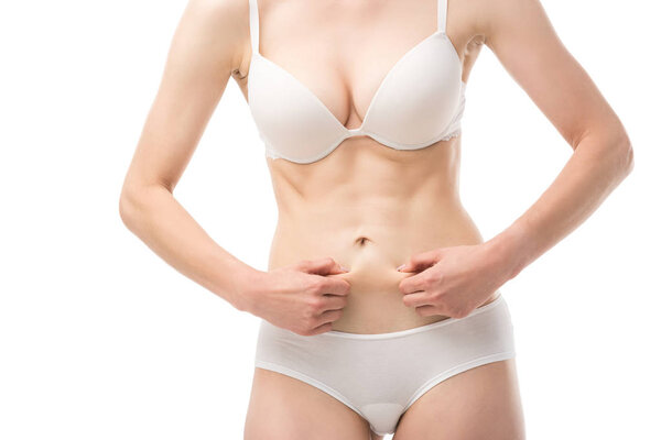 cropped view of woman in underwear holding skin on belly isolated on white