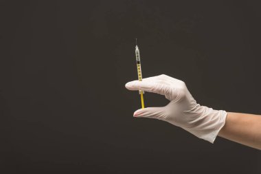 gri üzerinde izole şırınga tutan lateks eldiven doktor kırpılmış görünümü