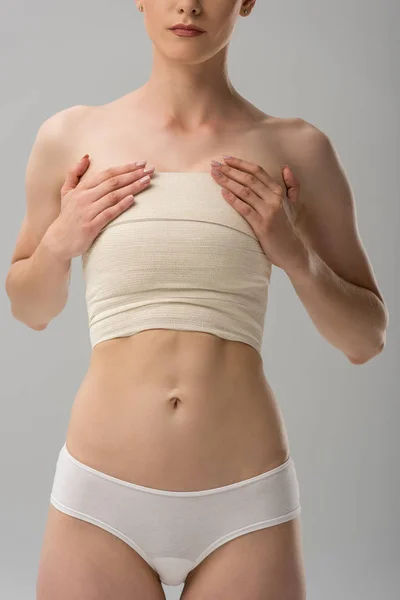 部分视图的妇女内裤与乳房绷带隔离在灰色 — 图库照片