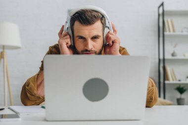yakışıklı adam müzik dinleme ve dizüstü ekrana bakarak 