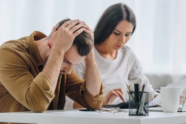 hesap makinesi kullanarak baş ve çekici kadın tutan üzgün ve yakışıklı adam 