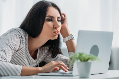 dizüstü bilgisayar kullanarak güzel ve esmer kadın seçici odak ve yüzleri yapma 