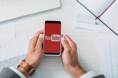 youtube uygulaması ile akıllı telefon tutan adam üst görünümü 