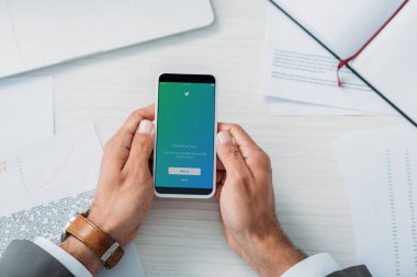twitter web sitesi ile akıllı telefon tutan adam üst görünümü