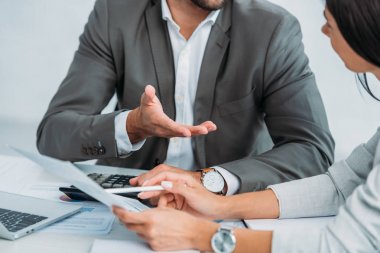belge yi tartışan takım elbiseli işadamı ve iş kadını kadının kırpılmış görünümü 