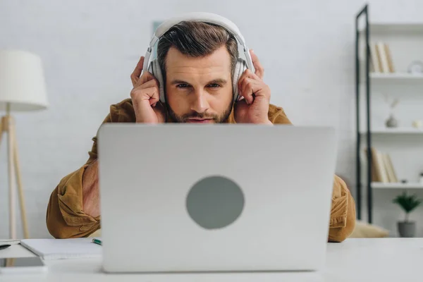 Pohledný Muž Který Poslouchá Hudbu Dívá Obrazovku Přenosného Počítače — Stock fotografie
