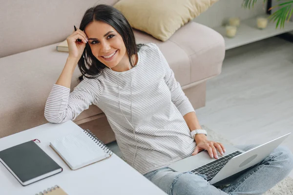 Όμορφη Γυναίκα Κάθεται Στο Πάτωμα Χαμογελαστός Και Κρατώντας Φορητό Υπολογιστή — Φωτογραφία Αρχείου