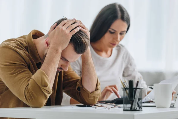 Sad Handsome Man Holding Head Attractive Woman Using Calculator — Stock Photo, Image