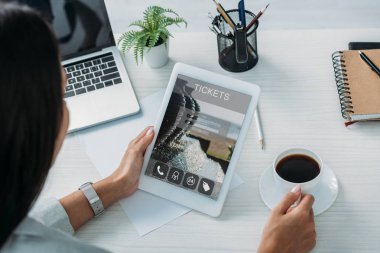 ekranda bilet web sitesi ile dijital tablet tutan kadın kırpılmış görünümü 