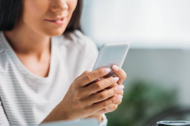 dudak ısırma ve akıllı telefon kullanarak kadın kırpılmış görünümü 
