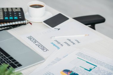 akıllı telefon, kahve, hesap makinesi, dizüstü bilgisayar ve kredi puanı ile fincan seçici odak 
