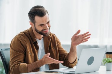 yakışıklı ve mutlu adam gülümseyen ve dizüstü ekran bakarak 